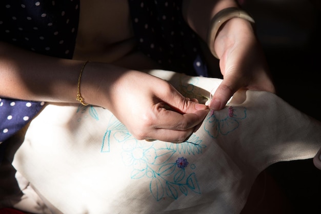 Warsztat haftu, ręce trzymają igłę